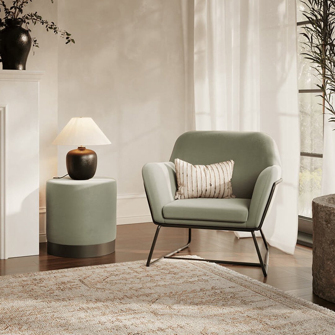 Lifestyle shot of the Charlie Armchair in a natural room with a sage green pouffe next to it