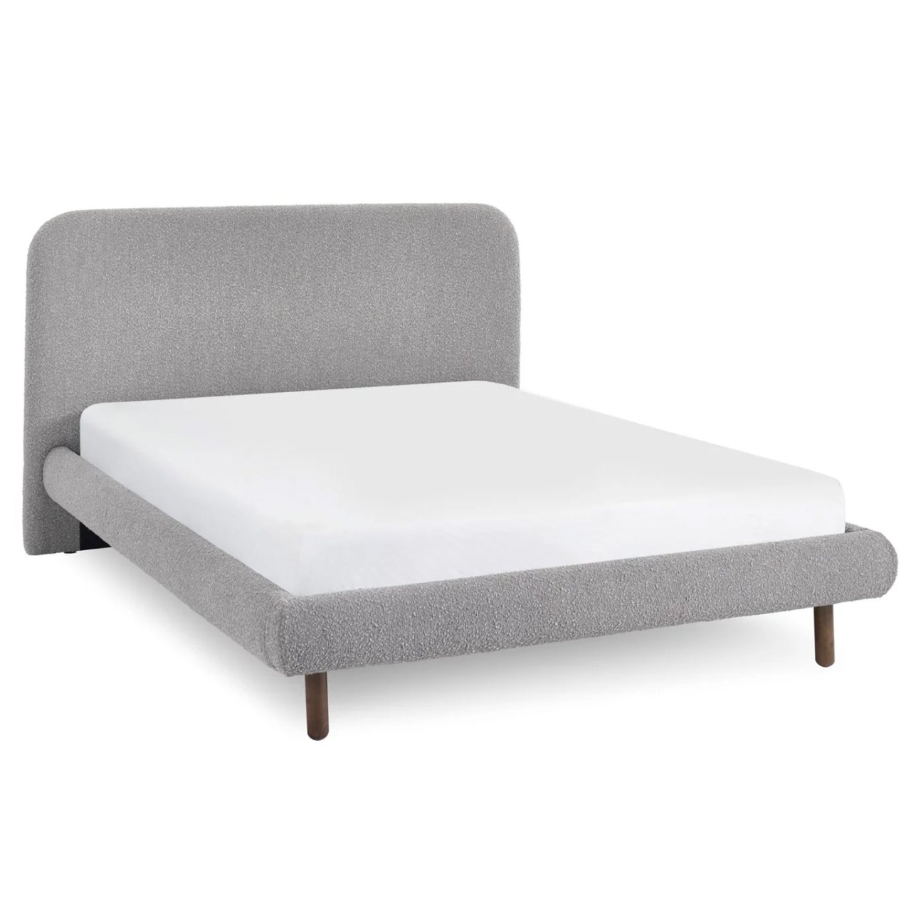 Angled view of the bed showing the headboard going all the way down to the ground on small stubs of feet.