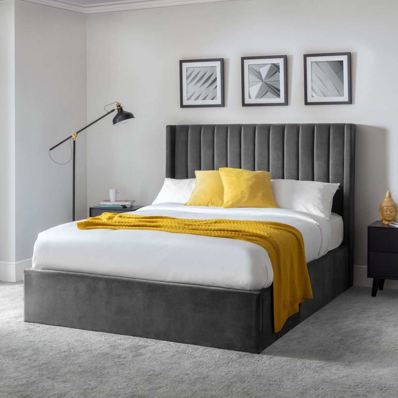 Lifestyle shot of the bed with yellow cushions and throw complementing the grey velvet of the upholstery