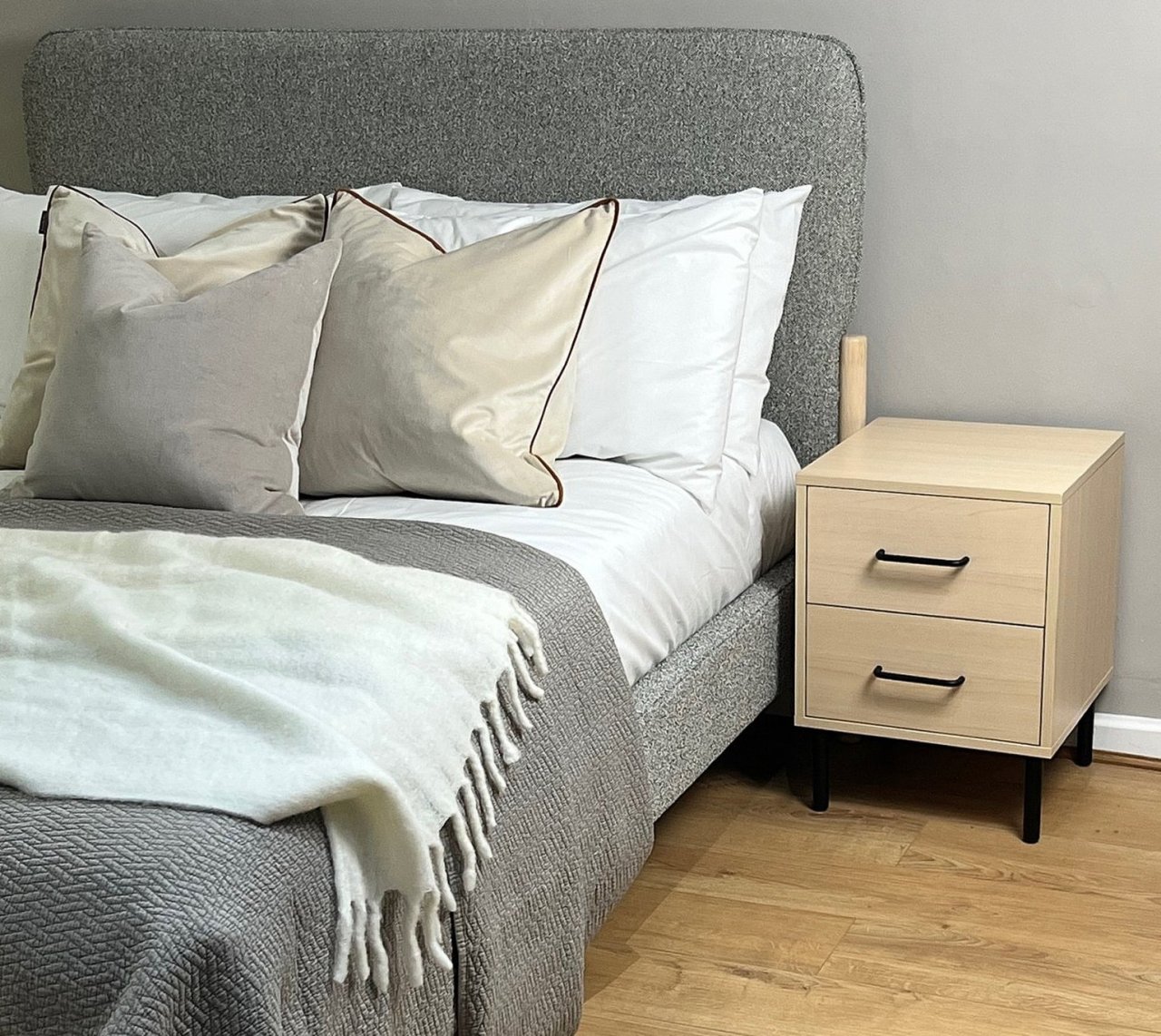 Lifestyle of the William two drawer bedside next to a modern grey bed showing the chemistry between the two pieces
