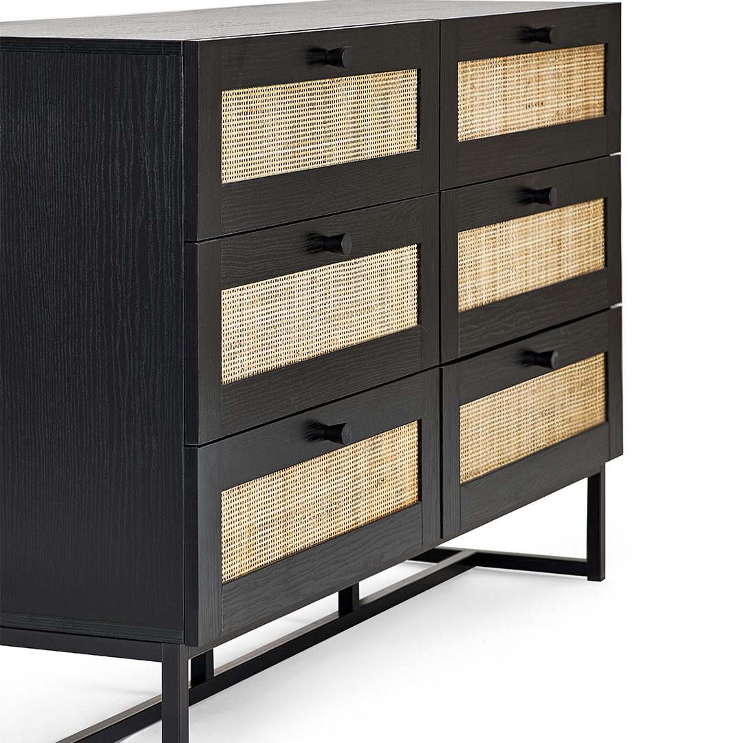 Side view if the drawer chest highlighting the contrast between the bright rattan and the dark veneer