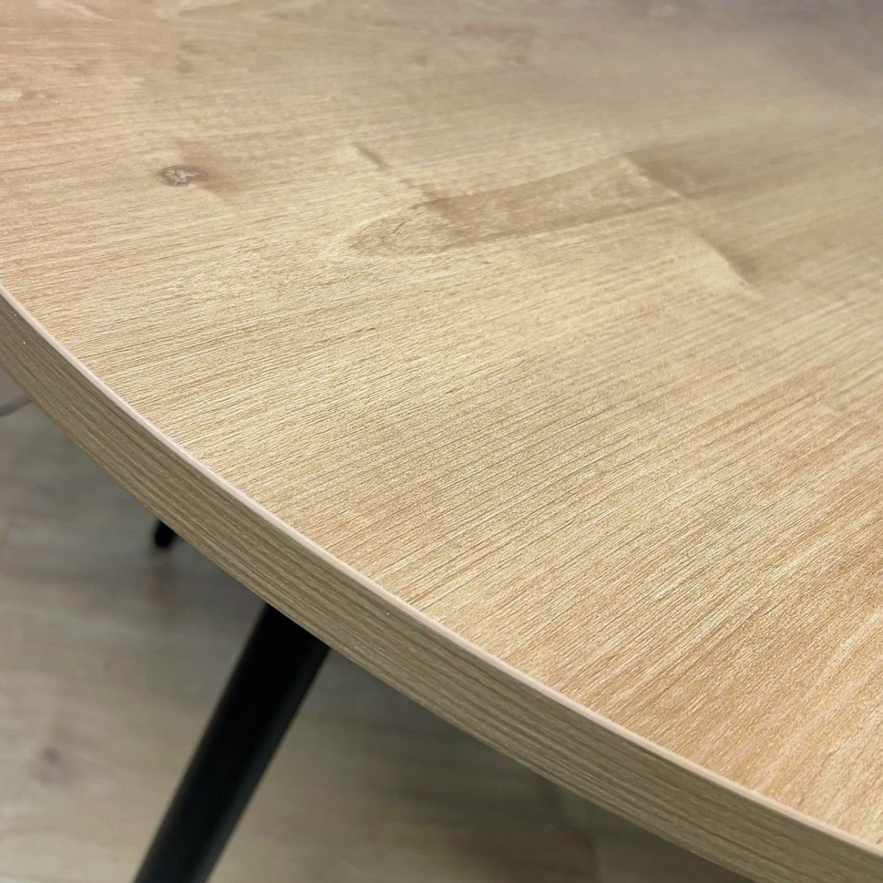 Zoom in on the edge of the round dining table with oak top