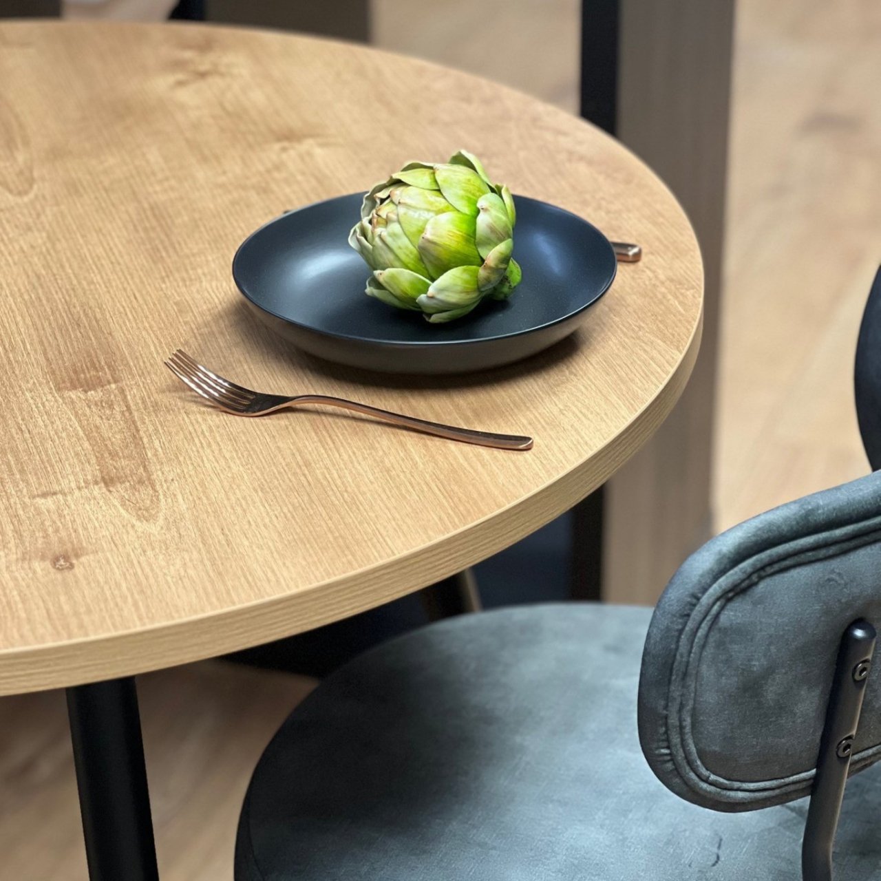 Zoomed in view of the round dinging table showcasing its oak woodgrain effect top