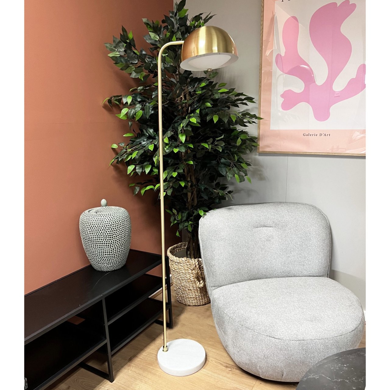 Lifestyle shot of the floor lamp next to a post-modern occasional chair