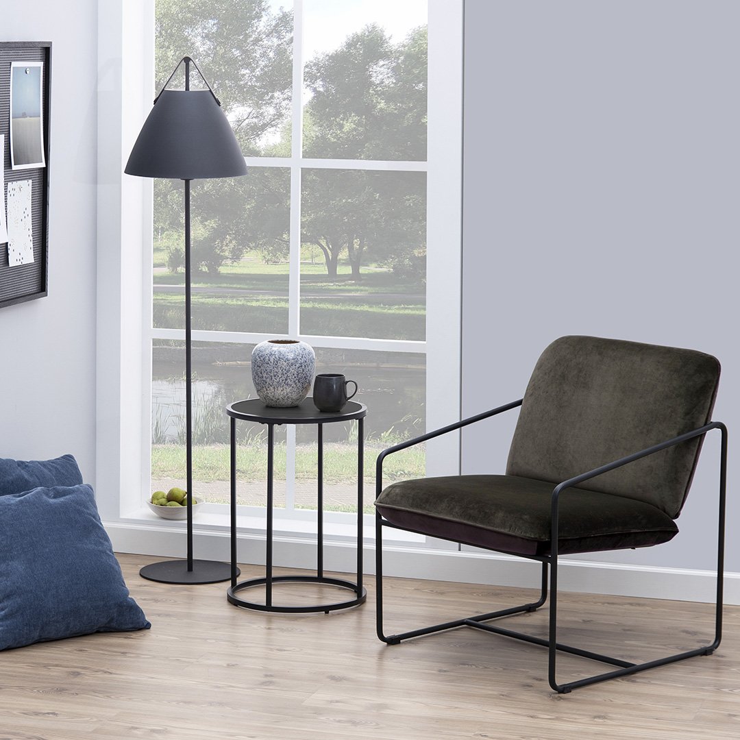 Lifestyle shot of the See Lamp Table next to a petite armchair and holding a vase and a tea mug