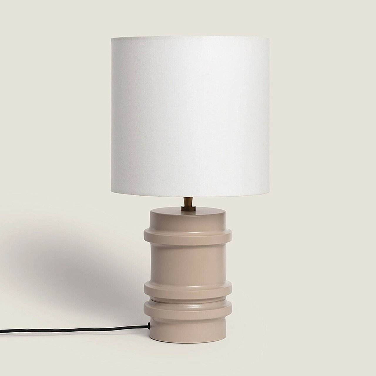 Table lamp with a cylindrical base and white linen shade
