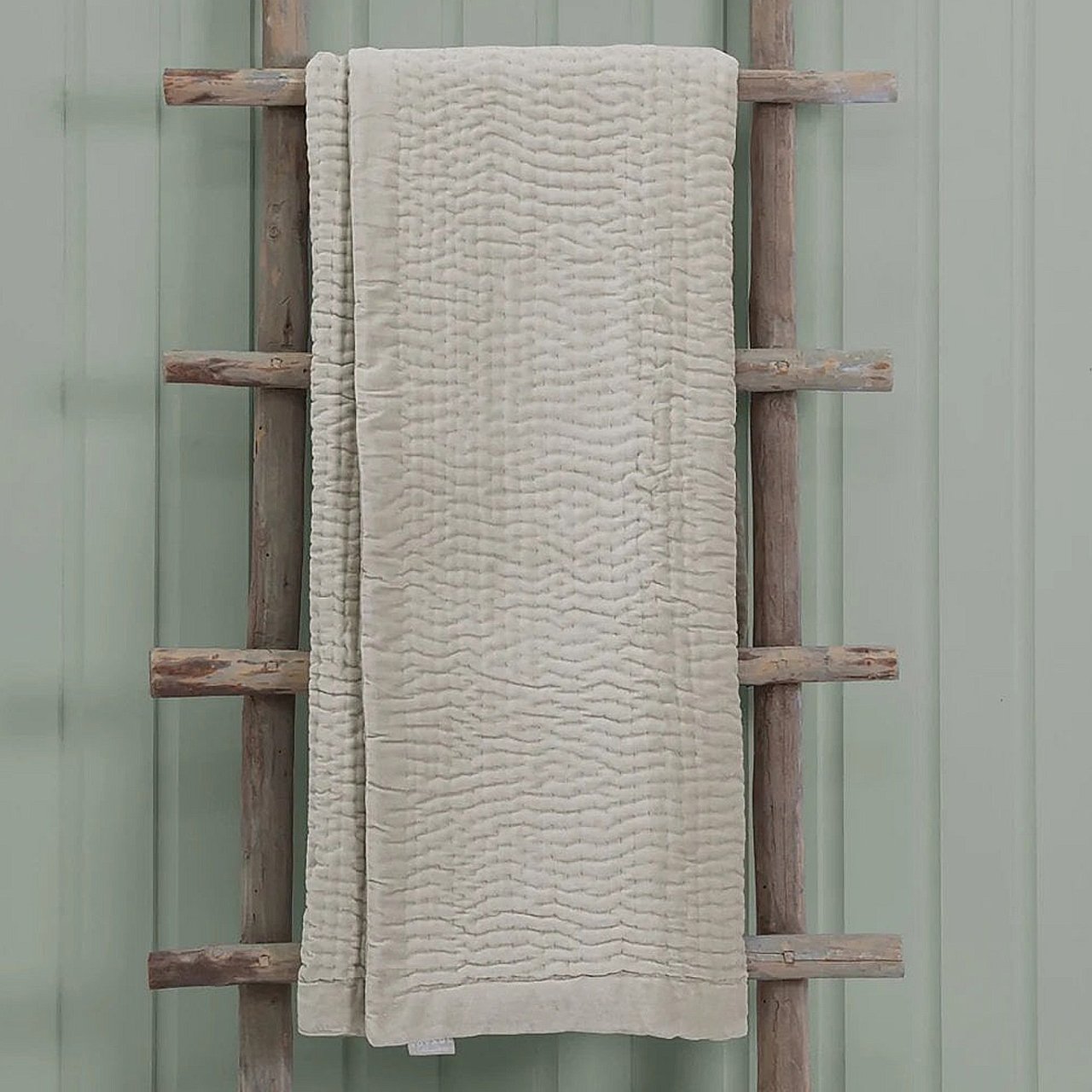 Quartz throw hanging on a rustic wooden rack