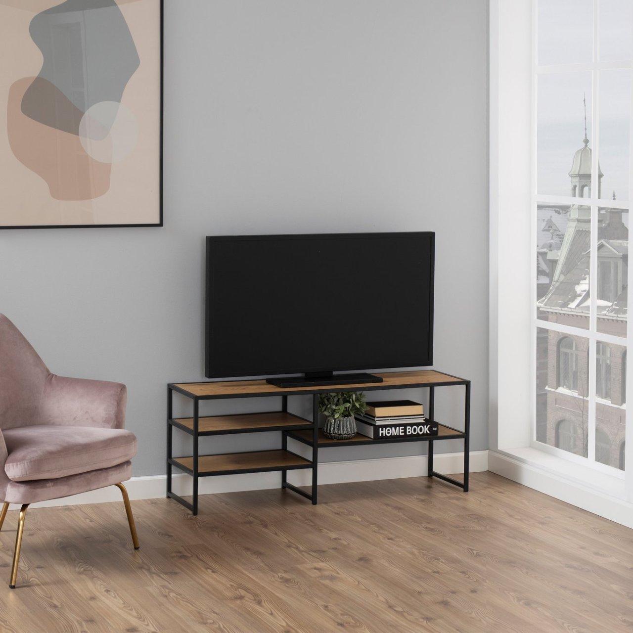 Lifestyle shot of the TV Unit with a large TV on top and books on the shelves