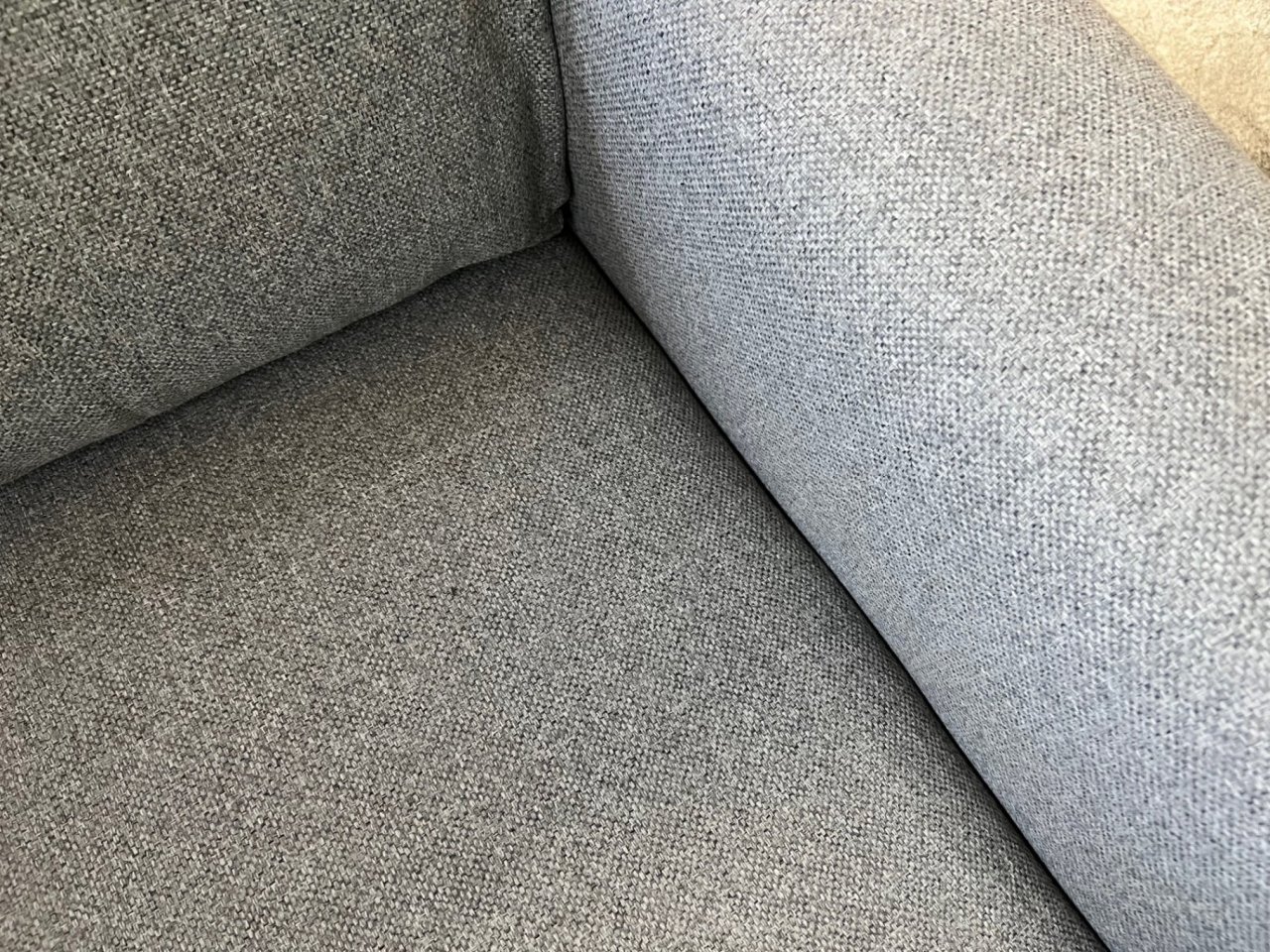 Zoom in on the fabric of the sofa bed at the intersection of the seat, backrest and armrest