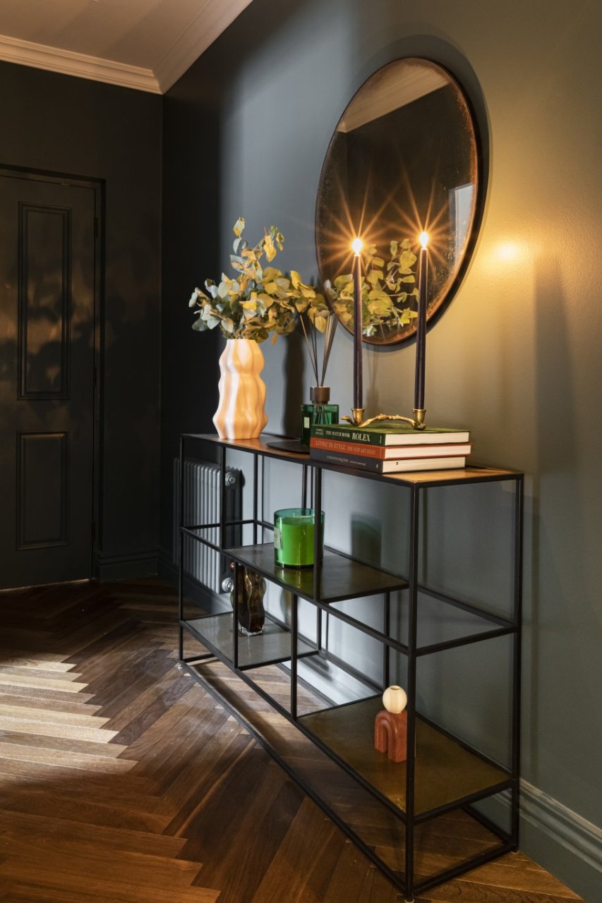 An entrée with a visually engaging shelf packed with decorations and luminous candles.