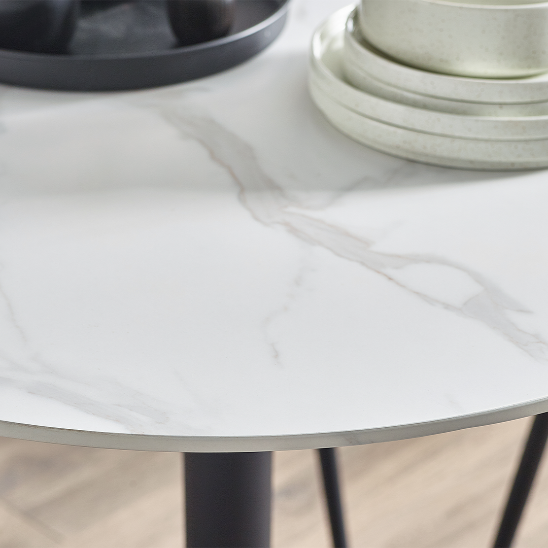 Close up of the round marble effect top with black and white plates on it for contrast